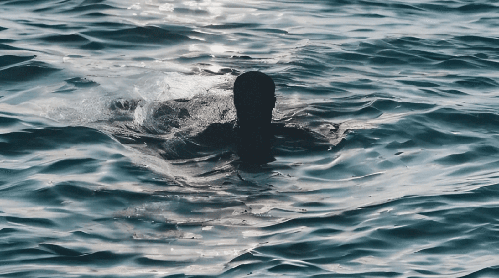 Person struggling to stay afloat in the ocean, symbolizing the challenges of mastering JavaScript.